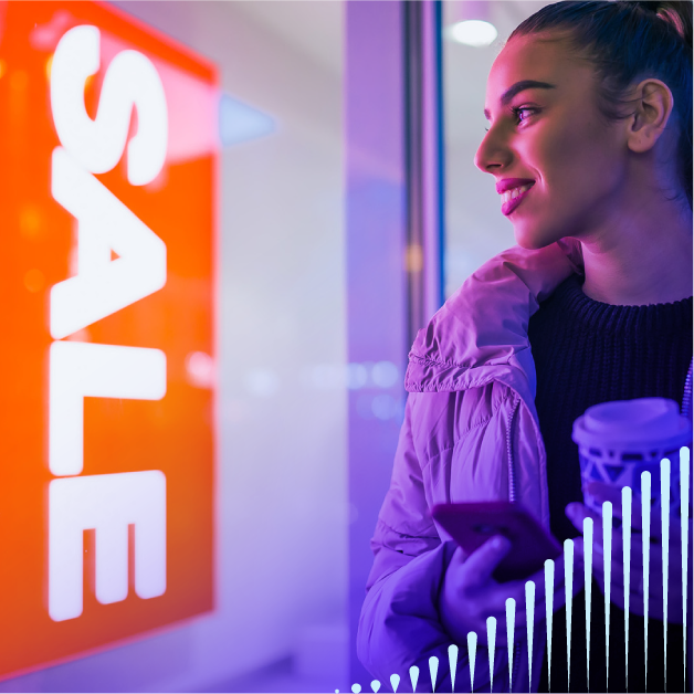 Woman looking at a sale sign on a store window