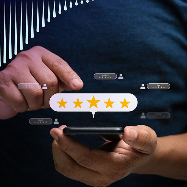 Closeup of one hand holding a phone and another about to tap the phone screen. There are star ratings floating around it