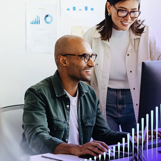 Man and woman smiling and looking at computer screen