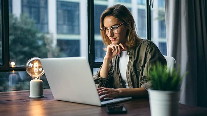 Woman sitting at table on laptop
