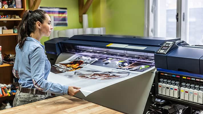 Woman using a large printing press