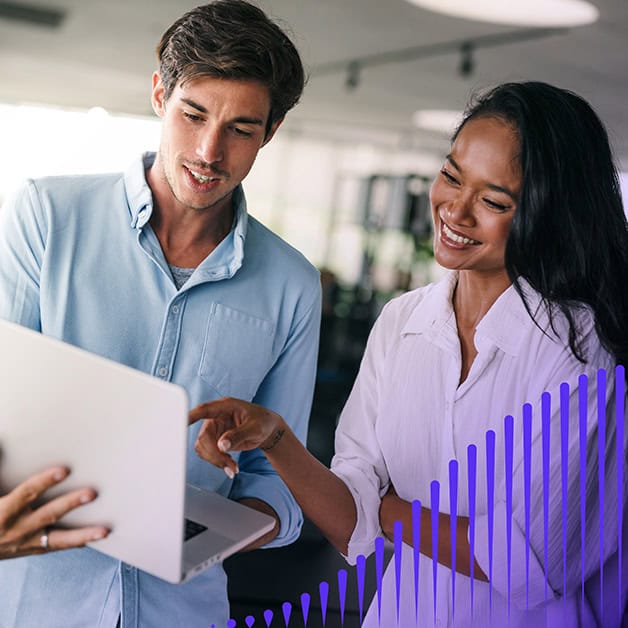 Man and woman smiling and looking at a laptop screen