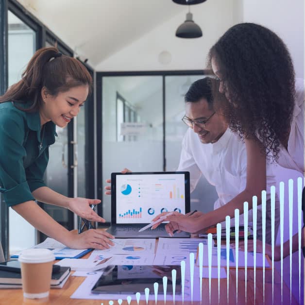 Three people looking at a graph with a laptop behind them